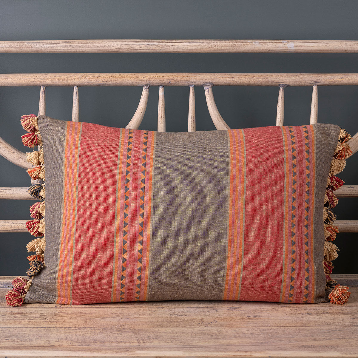 Jaipur stripe cotton cushion with tassel trim on a wooden garden bench