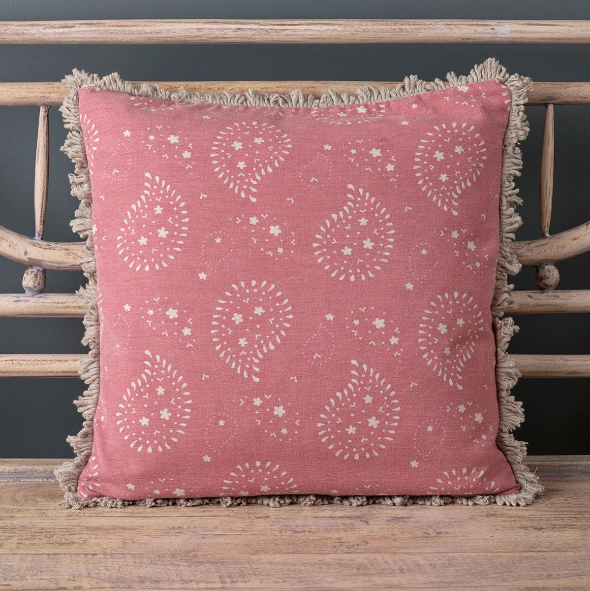 Rose Lullaby cushion, white paisley on dusky pink, on a painted bench