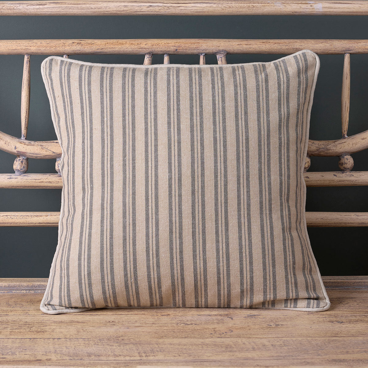 Charcoal beech ticking stripe cushion with piped trim on a bench