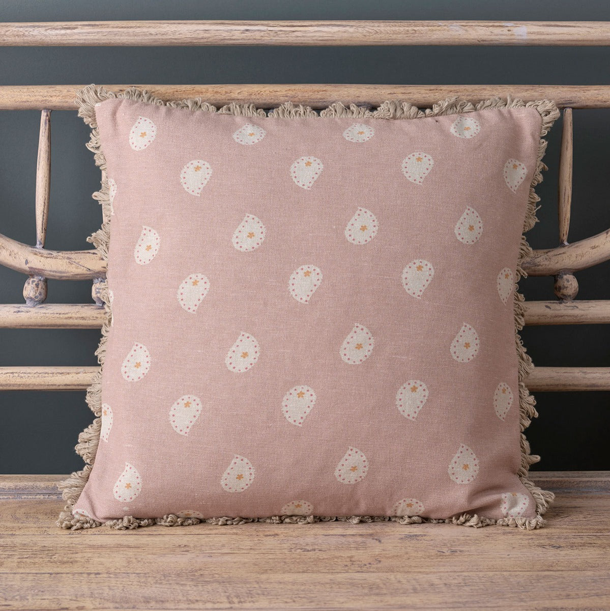 Dusky Pink Mika cushion with frilled edge on a painted bench