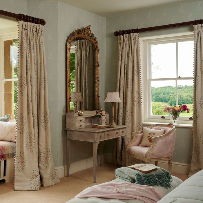 Embroidered Malathi curtains in a bedroom with a gilt mirror and dressing table