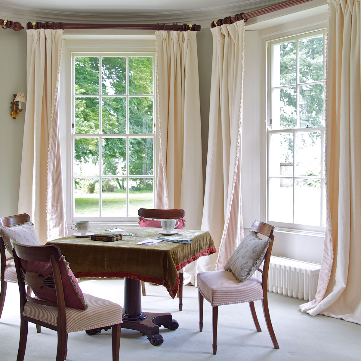 Ivory thickweave curtains at bay windows in a painted dining room