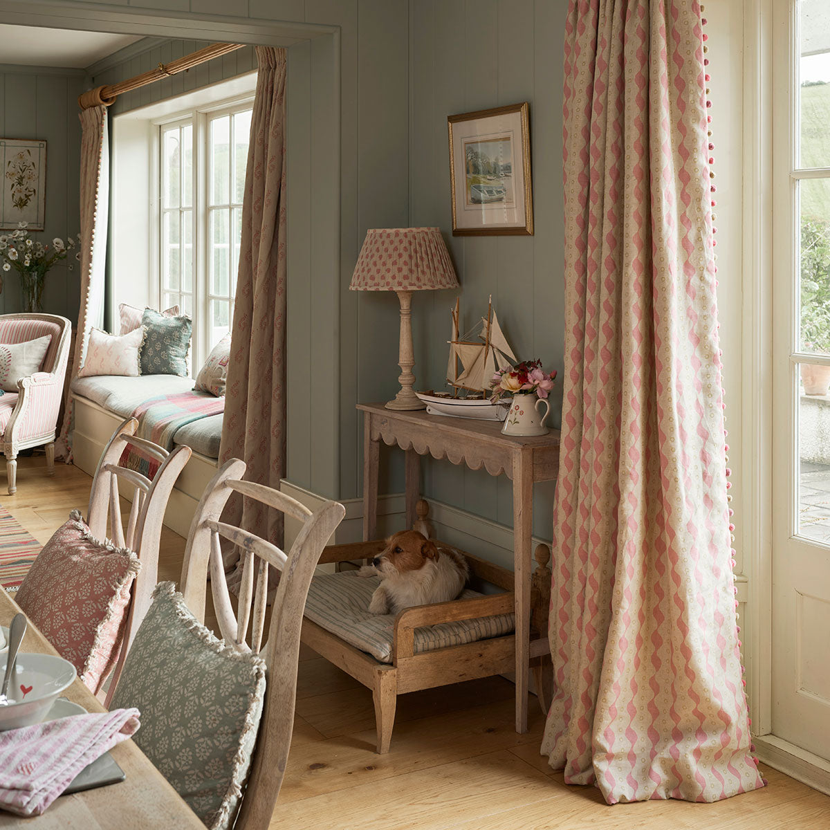 Bloomsbury linen curtains in a pale hallway with painted chairs and console