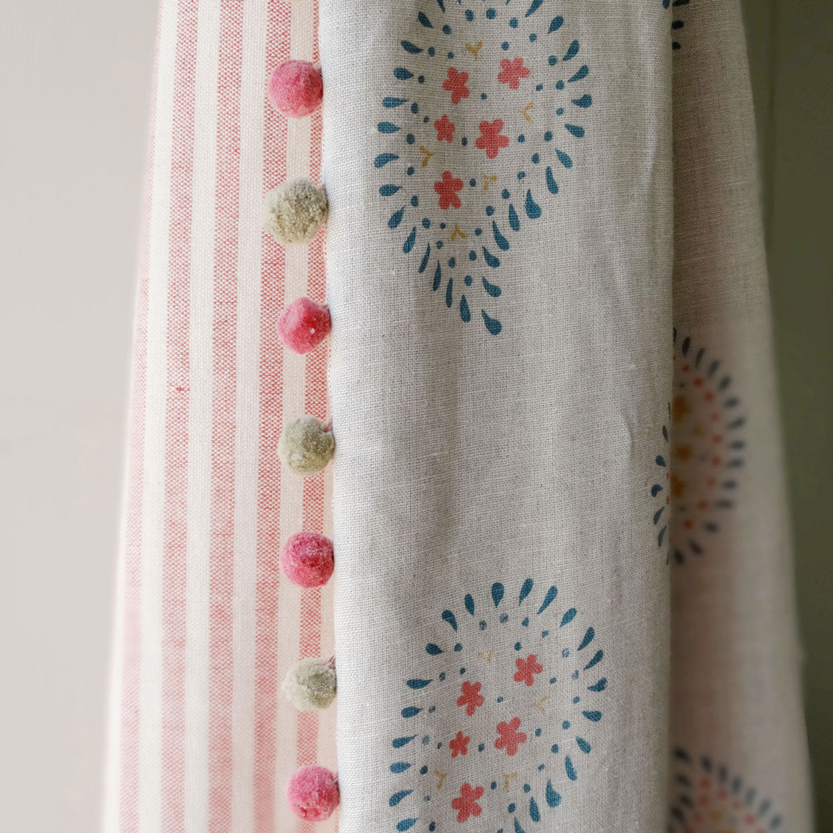 Malathi linen curtain edged with pink and green pom poms