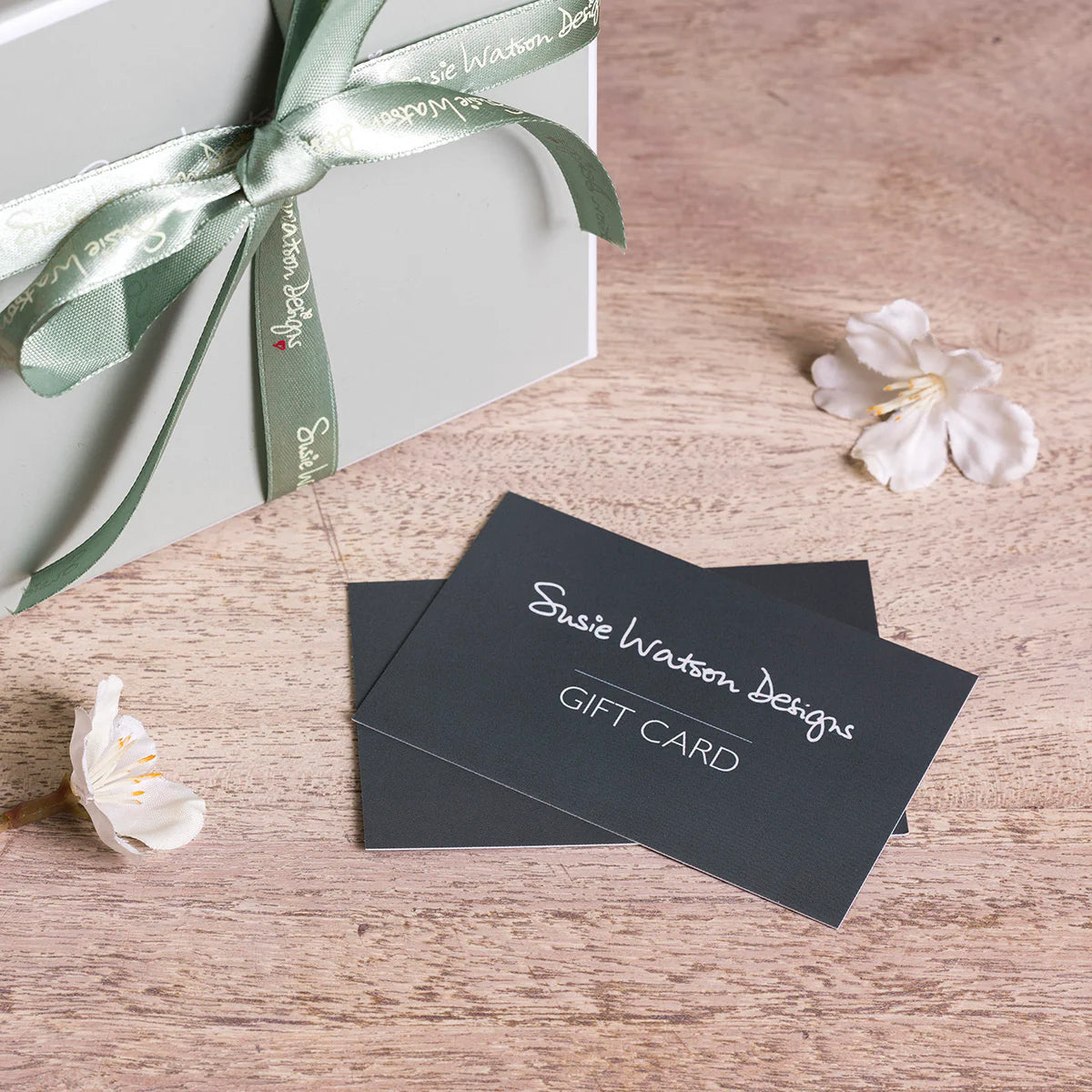 Susie Watson Designs gift cards with a ribboned box and blossom