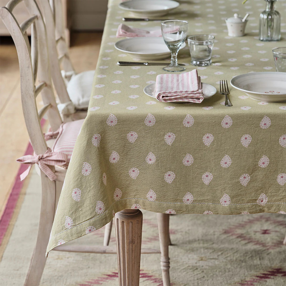 Green Mika tablecloth on a laid dining table with glasses and napkins