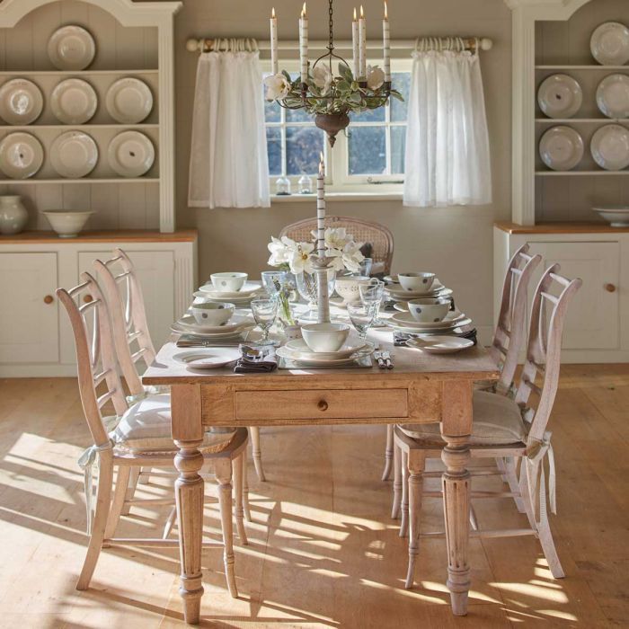 Kitchen with the Gustavian table laid by candlelight with painted chairs