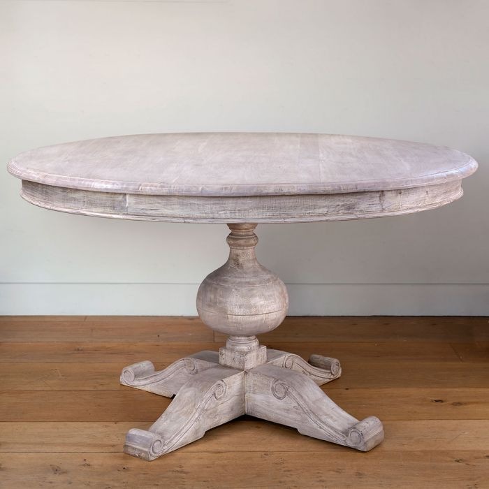 Round weathered acacia dining table with pedestal base, plain studio shot