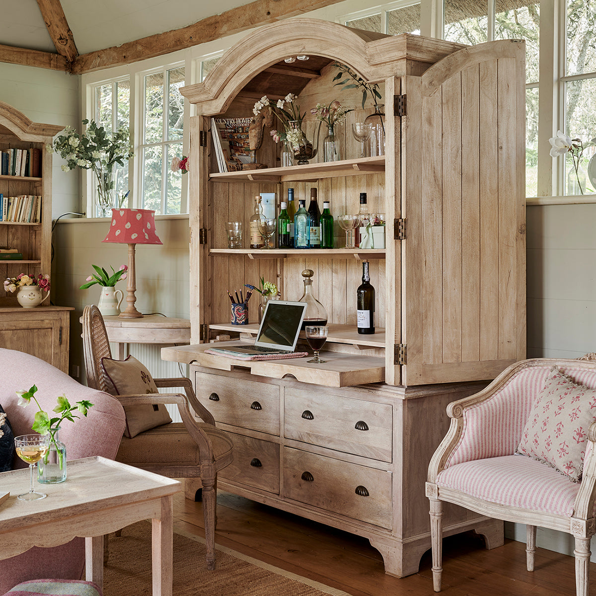 Gustavian armoire open to show shelves and drawers in a sitting room