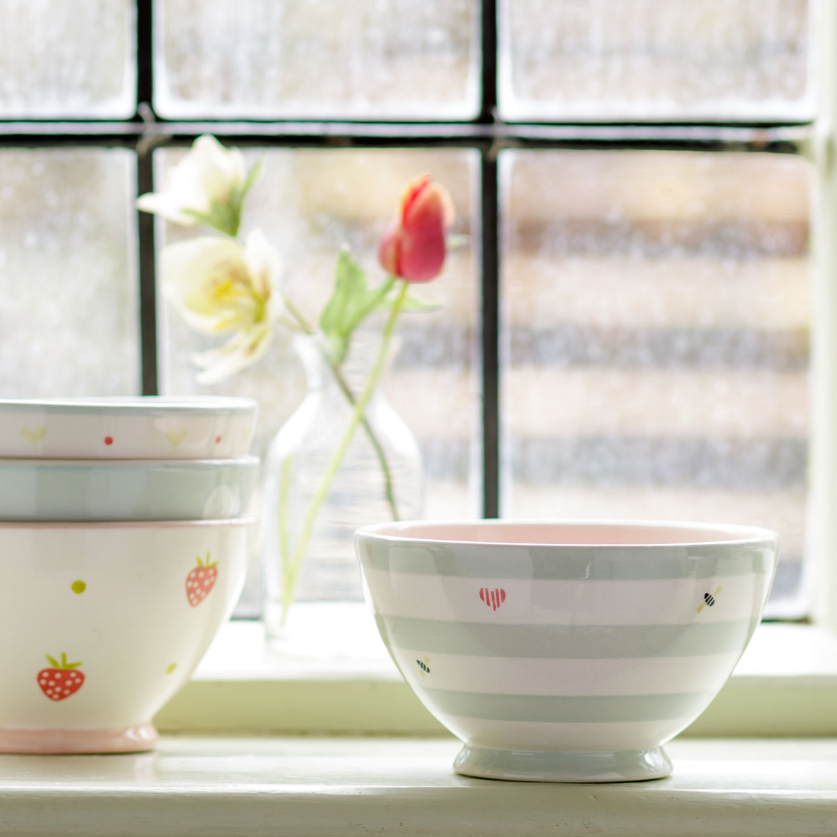 Honey Bees French bowls on a windowsill beside a jug of tulips