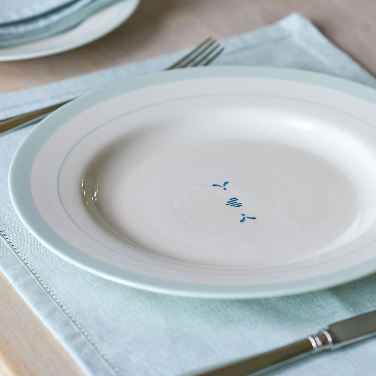 Indigo Blue Gustavian dinner plate on a linen napkin with knife