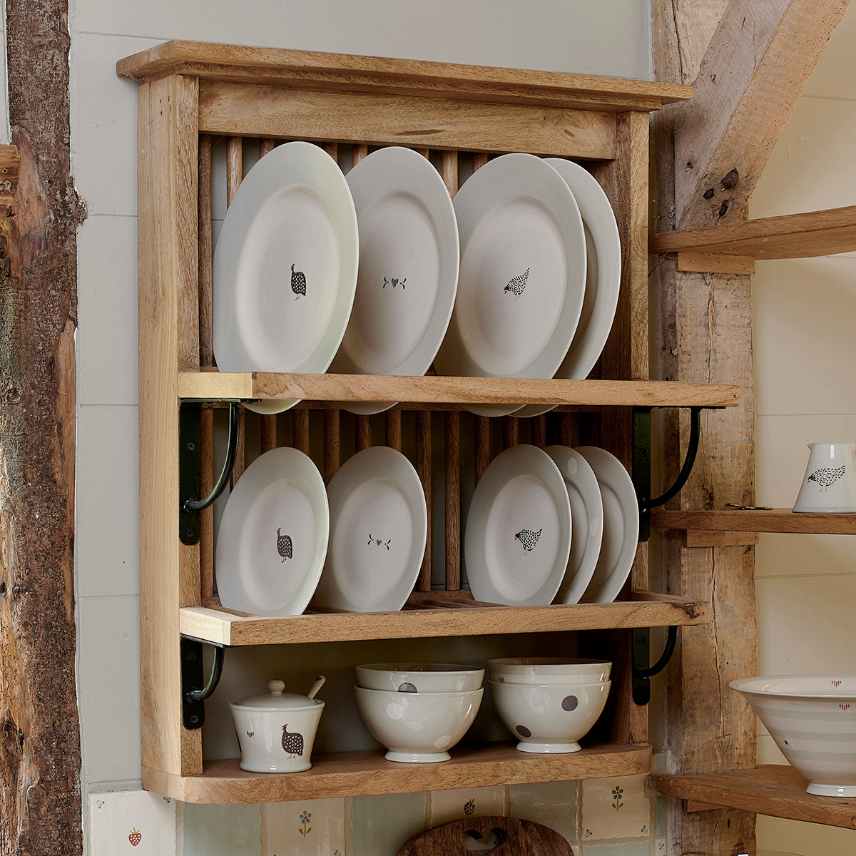 Wooden plate rack filled with Guinea Fowl plates and bowls