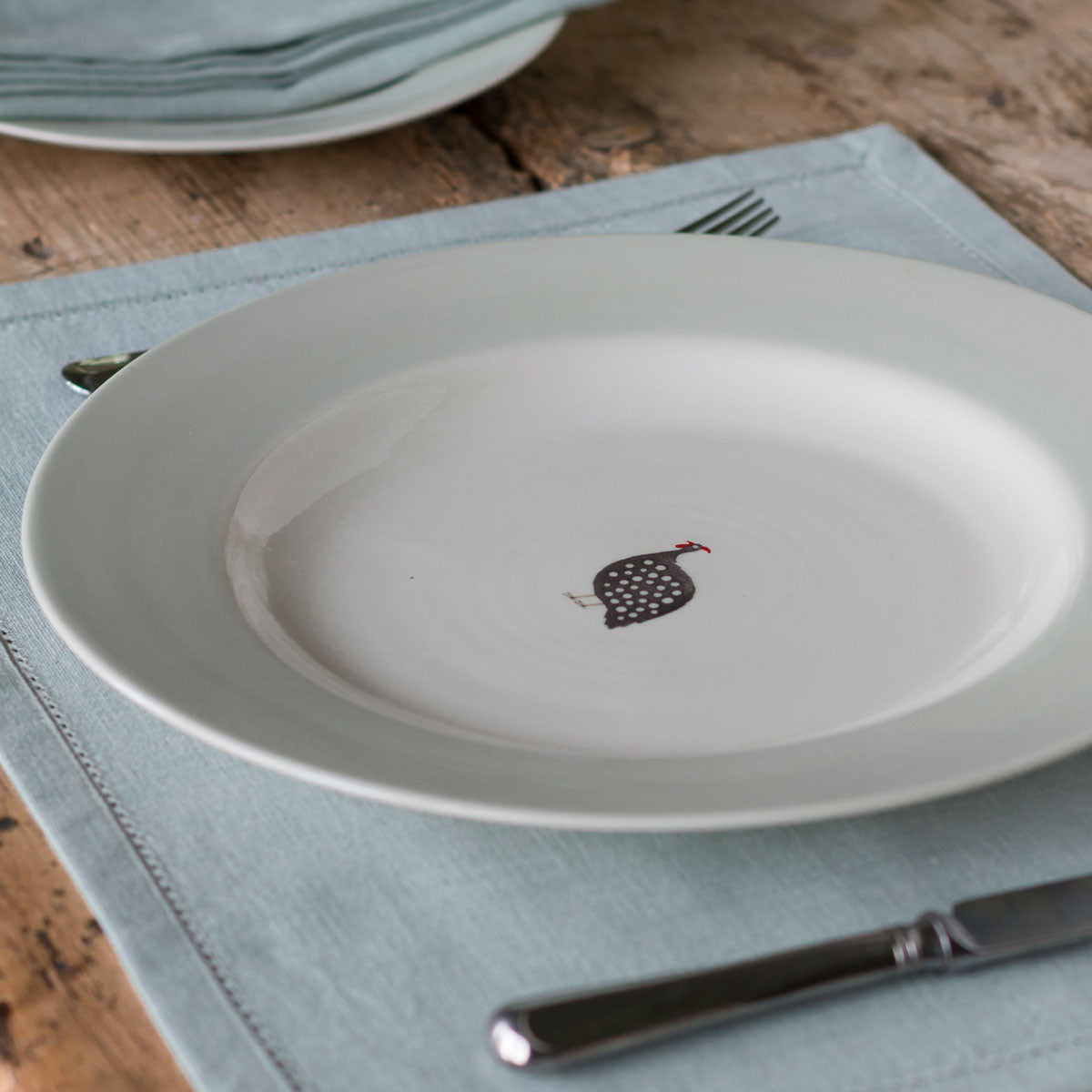 Guinea Fowl dinner plate on a linen napkin with cutlery, from above