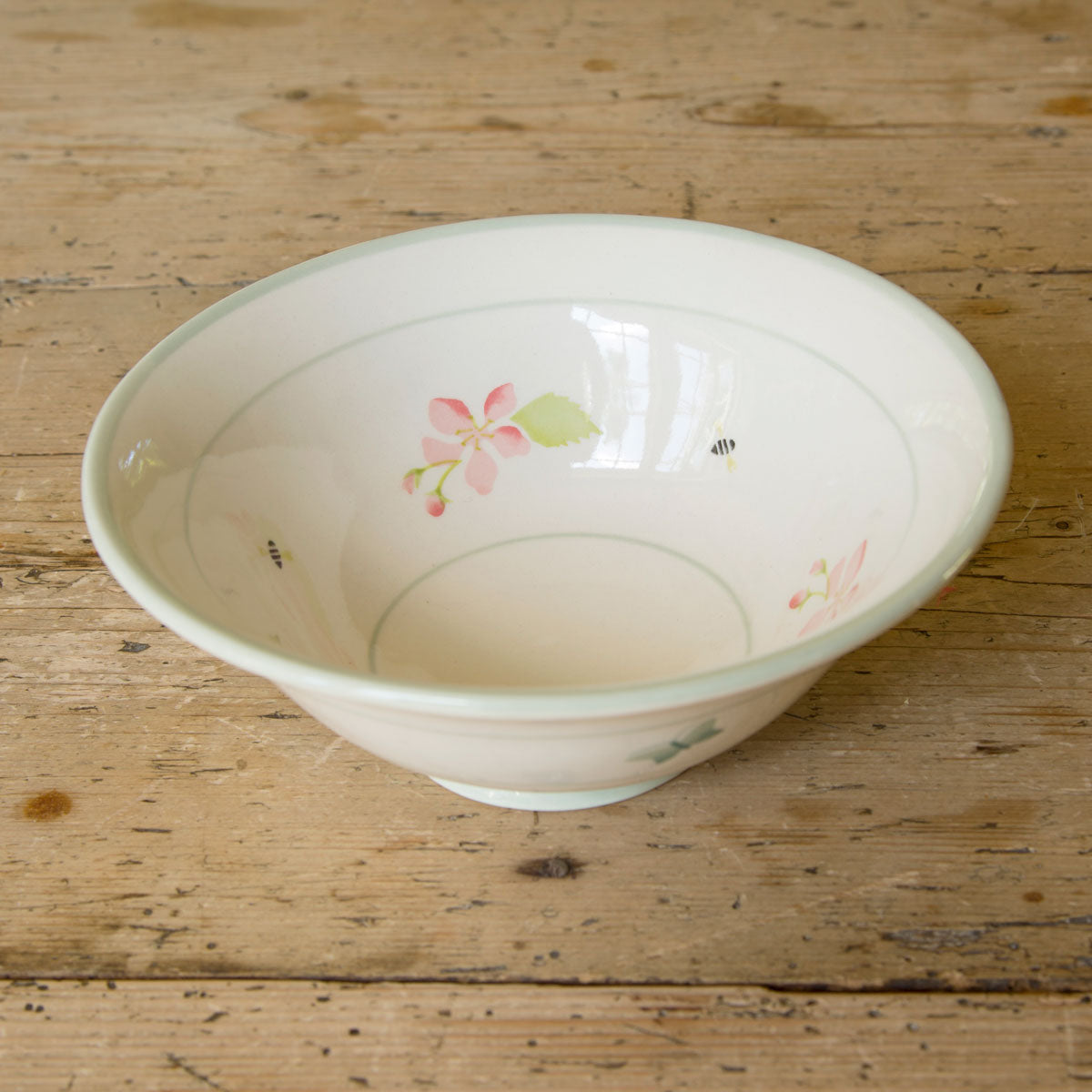 Pudding bowl on bare wood, blossom sprigs hand-painted inside the rim