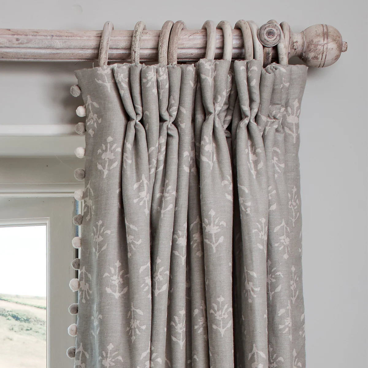 Grey pinch pleat curtains hanging from the weathered reeded curtain pole
