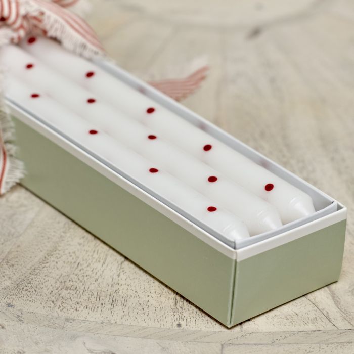 Red spot hand-painted candles laid inside their green gift box