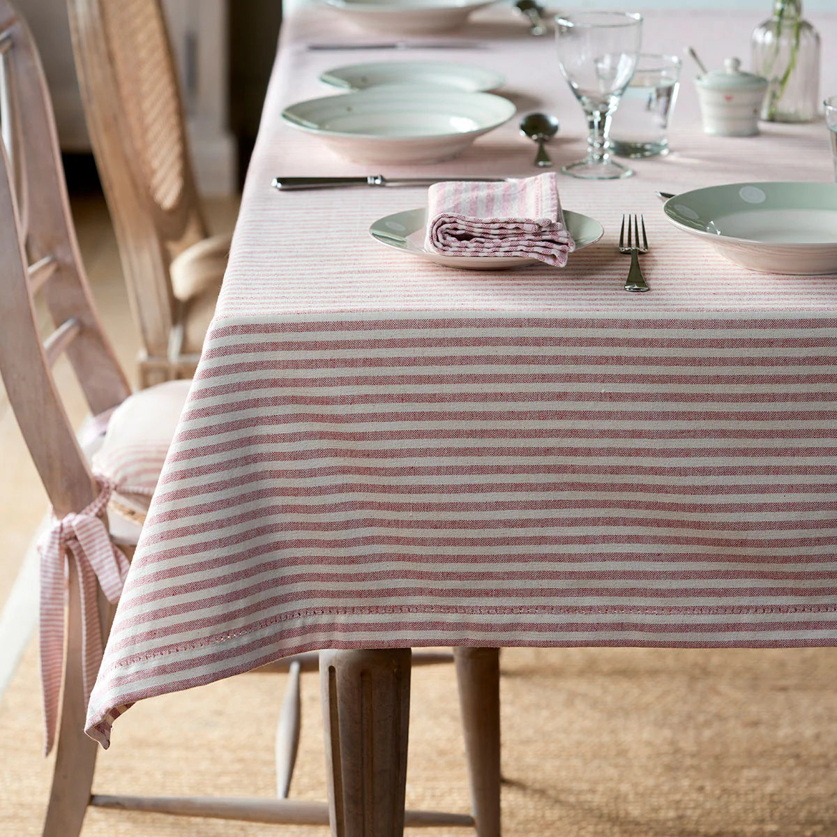 Red and ivory stripe thickweave tablecloth on a table laid with china