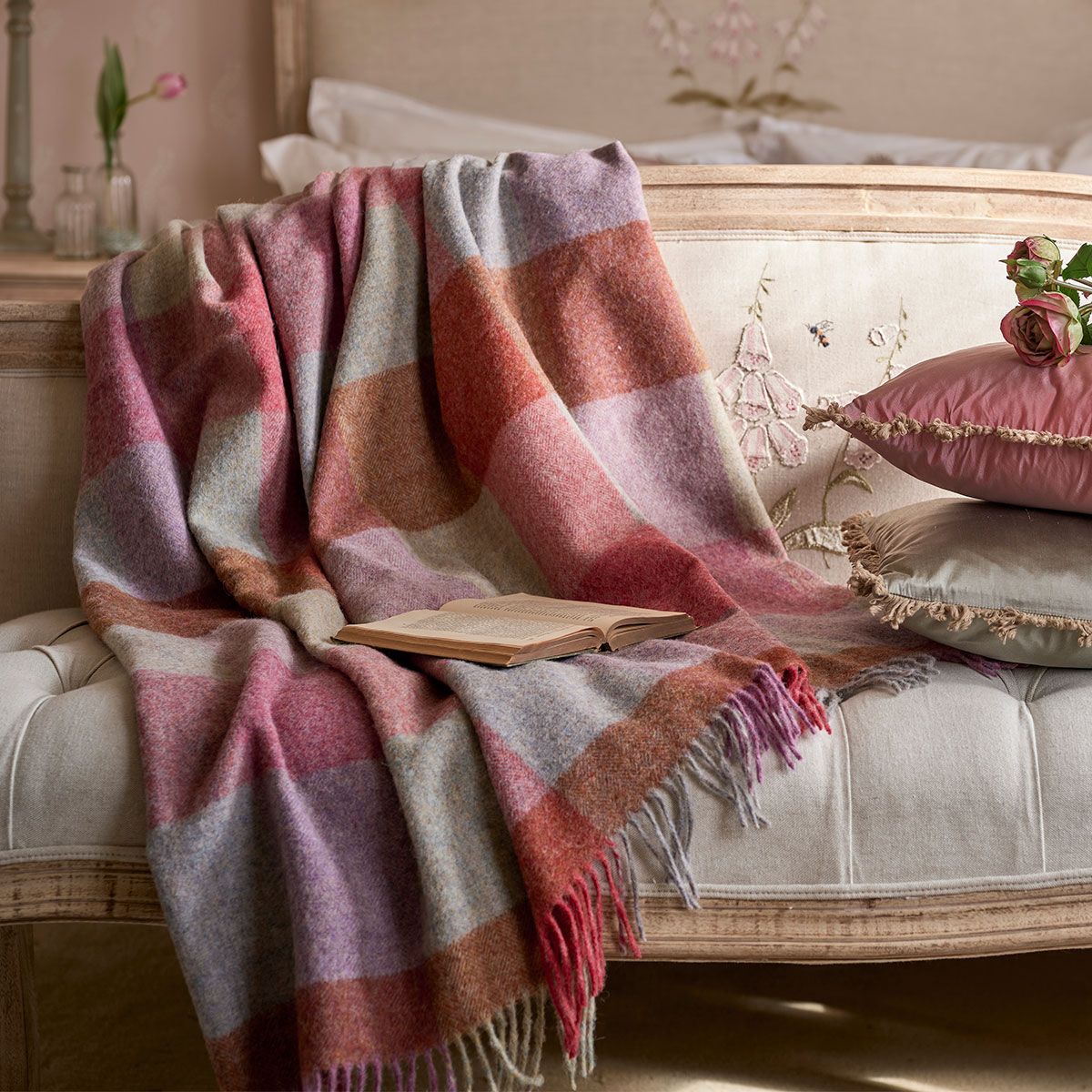 Harlequin wool throw in rose and violet spread across a daybed