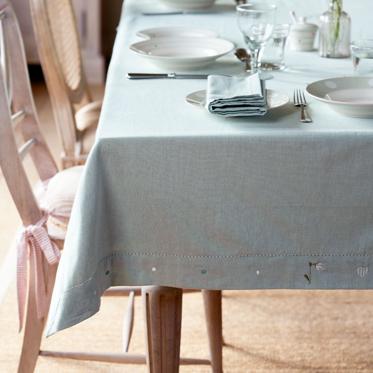 Duck egg snowdrop tablecloth draping a laid table with painted chairs