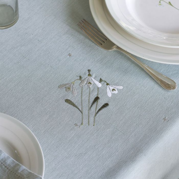 Embroidered snowdrop motif on duck egg cotton laid with plates and cutlery