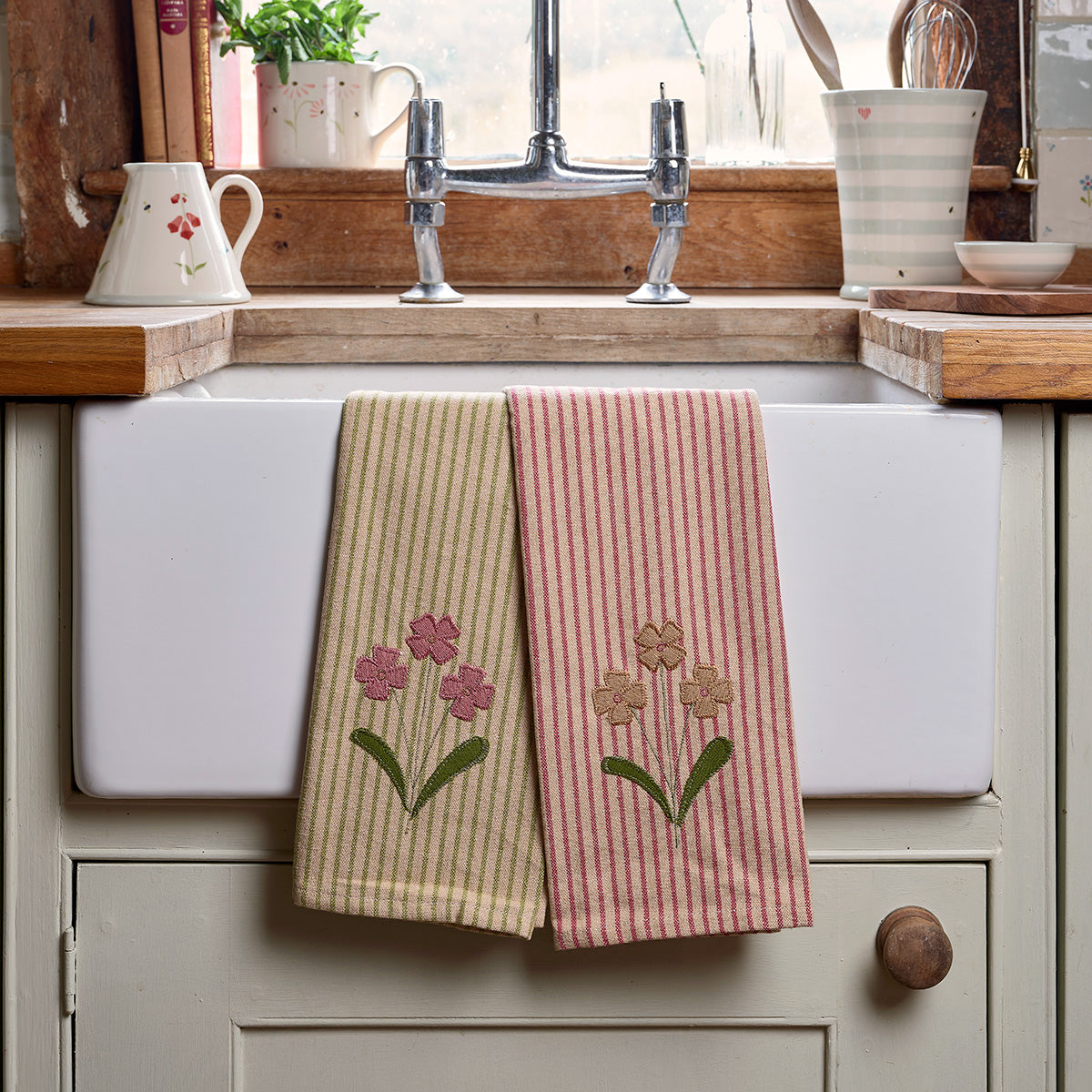 Daisy tea towels hanging in front of a deep butler sink
